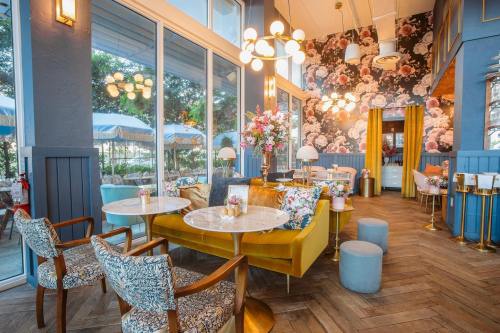 Brightly decorated café interior with floral wallpaper, elegant seating, and stylish lighting. Cozy and inviting atmosphere.
