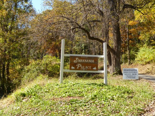 Sign for Swannanoa Palace, surrounded by trees and autumn foliage, with a smaller sign for apple picking details.
