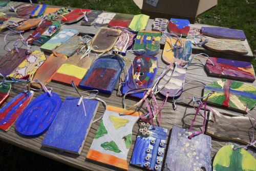 Colorful handmade art pieces displayed on a table, featuring various designs and tied with ribbons.