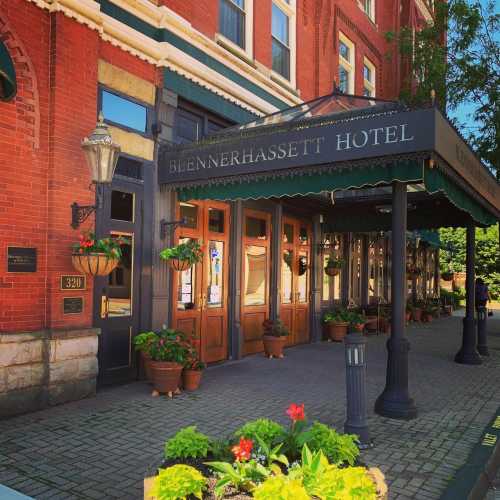 Exterior view of the Blennerhassett Hotel, featuring a covered entrance and potted plants along the walkway.