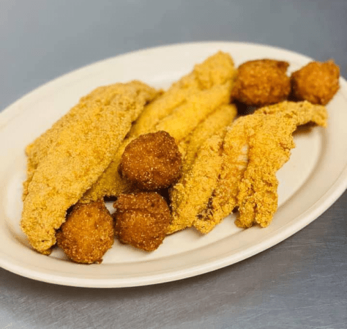 A plate of golden-fried fish fillets and crispy hushpuppies, served on a white dish.