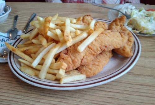 A plate of golden fried fish fillets served with a generous portion of French fries.