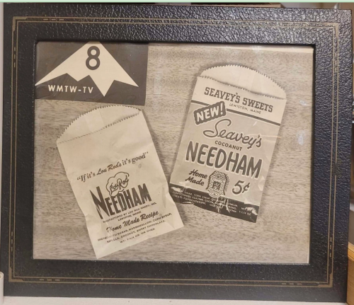 Framed vintage advertisements for Seavey's Sweets and Needham, featuring old-fashioned packaging and pricing.