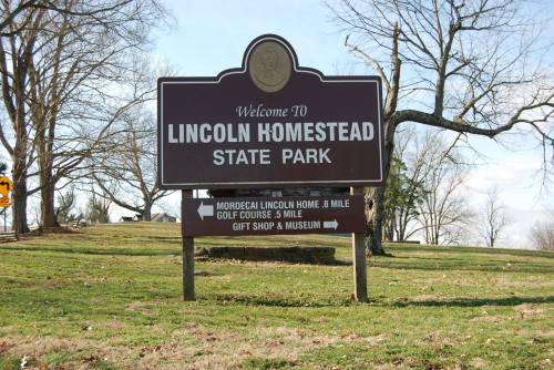 Sign welcoming visitors to Lincoln Homestead State Park, with directions to the golf course and gift shop.