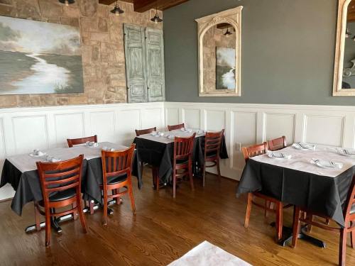 A cozy restaurant interior with wooden tables, black tablecloths, and decorative mirrors on the walls.