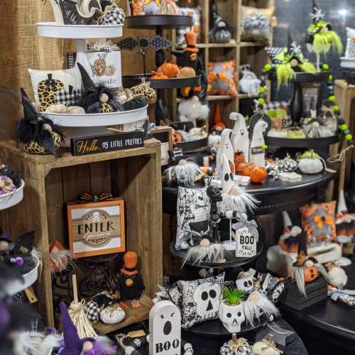 A festive display of Halloween decorations, featuring pumpkins, witches, and various themed items in black and orange.