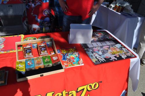 A table displaying MetaZoo trading cards, a game board, and promotional materials at an event.