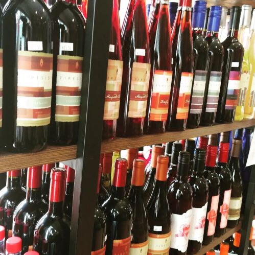 A display of various wine bottles arranged on shelves, featuring different colors and labels.