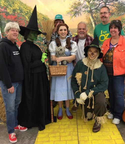 A group of people dressed as characters from "The Wizard of Oz," including Dorothy, the Scarecrow, and the Wicked Witch.