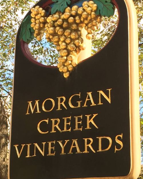 Sign for Morgan Creek Vineyards featuring golden grapes and decorative elements.