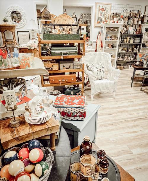 A cozy vintage shop filled with eclectic decor, furniture, and collectibles, featuring a mix of colors and textures.