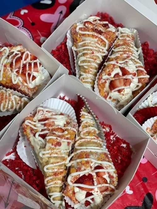 Delicious dessert cones filled with strawberries, drizzled with white icing, and topped with colorful sprinkles.
