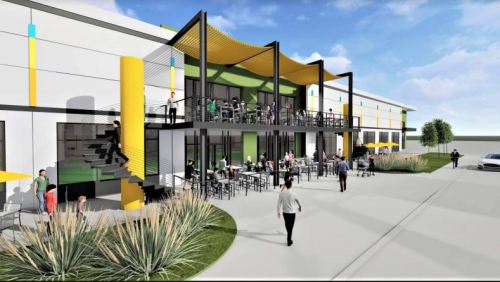 A modern building with outdoor seating, people socializing, and vibrant yellow and green accents under a blue sky.
