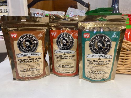 Three bags of Craig's seasoning mix: Extra Crispy, Mild Cajun, and Original, displayed on a table.