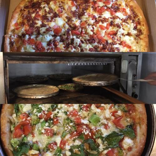 A close-up of two pizzas: one topped with bacon and tomatoes, the other with broccoli and spinach, in a pizza oven.
