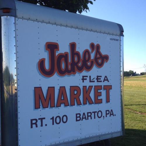 Sign for Jake's Flea Market, located on Route 100 in Barto, Pennsylvania. Bright lettering on a silver trailer.