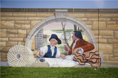 A mural depicting two historical figures discussing plans, with a scenic background and the year "1793" above.
