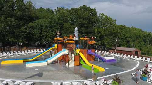 A colorful water slide park with multiple slides surrounded by lounge chairs and trees in the background.