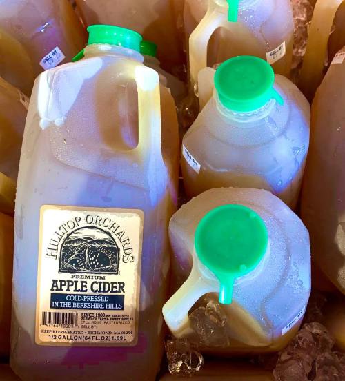 Several jugs of apple cider with green caps, labeled "Hill-Top Orchards, Premium Apple Cider, Berkshire Hills."