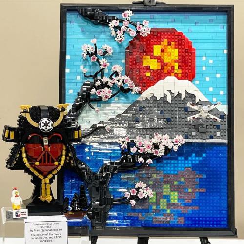 A LEGO art piece featuring a Japanese landscape with cherry blossoms, Mount Fuji, and a red sun, alongside a samurai figure.