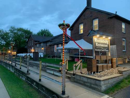 Exterior of Ronneburg Restaurant at dusk, featuring a sign, pathway, and outdoor seating area.