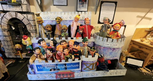 A colorful display of puppets from "Mr. Rogers' Neighborhood" arranged in a castle-themed setting.