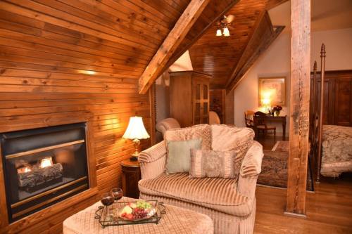 Cozy living area with wooden walls, a fireplace, and comfortable seating, creating a warm, inviting atmosphere.