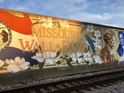 Mural featuring "Missouri Wall of Fame" with flowers, a bluebird, and portraits of notable figures.