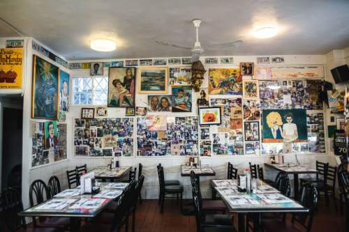 A cozy restaurant interior with tables and walls adorned with various framed photos and artwork.