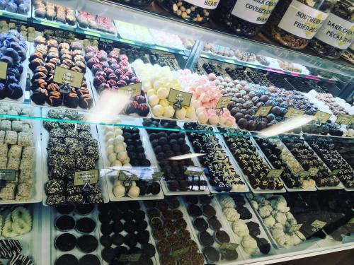 A colorful display of assorted chocolates and confections in a glass case, featuring various shapes and flavors.