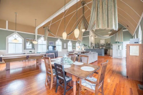 Spacious, elegantly decorated dining area with wooden furniture and large windows, featuring a cozy, inviting atmosphere.