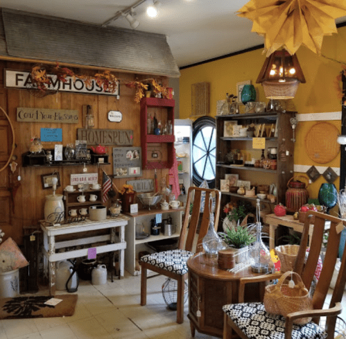 Cozy interior of a rustic shop featuring wooden furniture, decor items, and autumn-themed decorations.