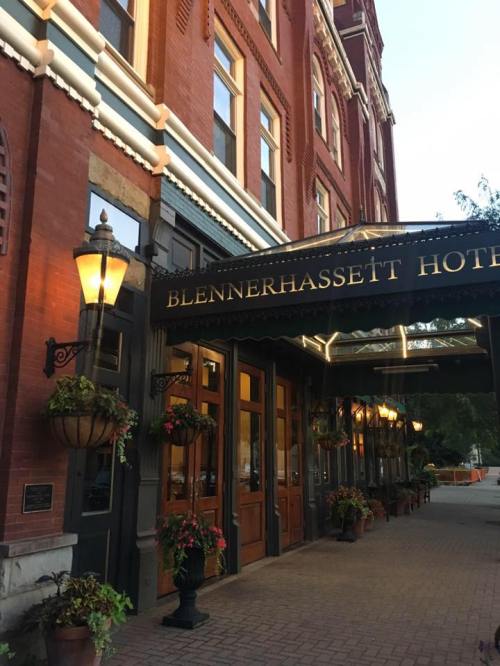 Entrance of the Blennerhassett Hotel, featuring brick architecture and hanging flower baskets.