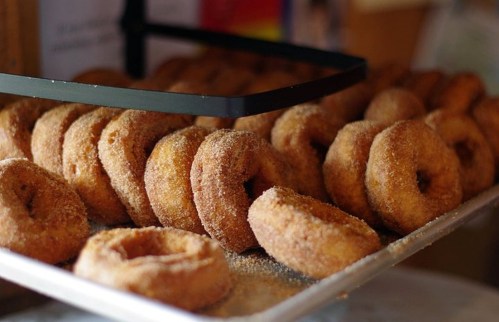A tray of freshly made cinnamon sugar donuts stacked neatly.