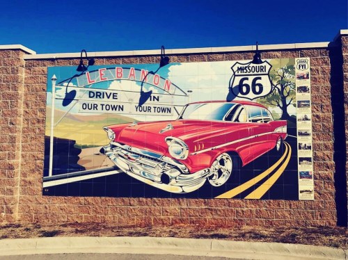 A vibrant mural featuring a classic red car and the text "Lebanon, Missouri, Route 66" against a blue sky backdrop.
