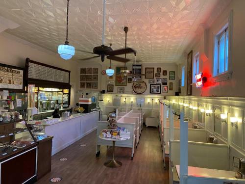 Interior of a vintage ice cream shop with a decorative ceiling, booths, and a counter displaying ice cream treats.