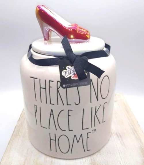 A decorative jar with the phrase "There's No Place Like Home" and a red glittery high heel on top.