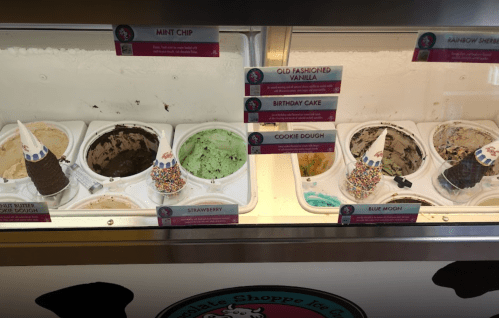 Ice cream display with various flavors: Mint Chip, Old Fashioned Vanilla, Birthday Cake, Cookie Dough, Strawberry, Blue Moon, and Rainbow Sherbet.