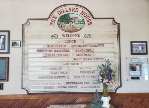 Signboard at The Dillard House displaying lunch menu items and beverages, with decorative elements and flowers.