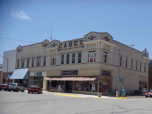 Historic building with "Case's" sign, featuring shops like Rivendell Book Store and a sunny street scene.
