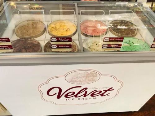 A display case of Velvet ice cream featuring various flavors in labeled containers.