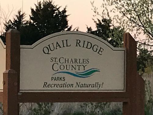 Sign for Quail Ridge in St. Charles County, featuring the text "Parks Recreation Naturally!" against a natural backdrop.
