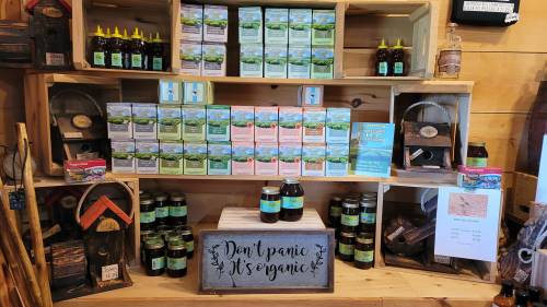 A wooden display featuring various organic products, including jars and boxes, with a sign that reads "Don't Panic, It's Organic."
