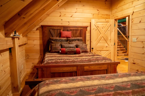 Cozy wooden bedroom with two beds, rustic decor, and a warm, inviting atmosphere.