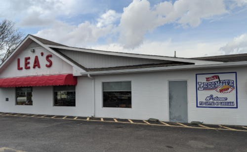 Exterior of Lea's restaurant with a red awning and a sign for LeCompte, showcasing Louisiana cuisine.