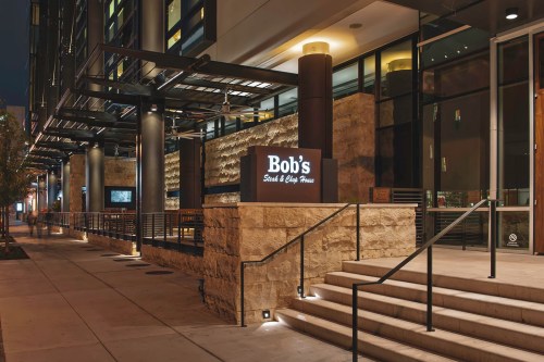 Exterior view of Bob's Steak & Chop House at night, featuring a stone facade and illuminated signage.