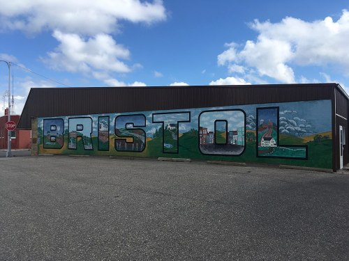A large mural on a building spelling "BRISTOL" with a scenic background of hills and clouds.