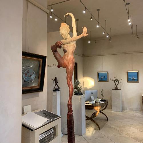 A tall, elegant sculpture of a dancer in a gallery, showcasing dynamic movement and artistic expression.