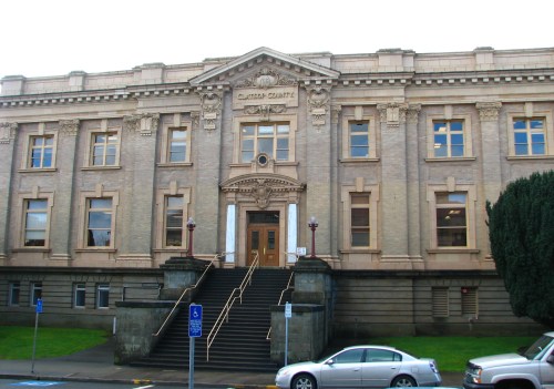 Historic building with ornate architecture, featuring stairs leading to a grand entrance and "Clatsop County" inscription.
