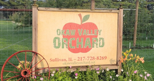 Sign for Okaw Valley Orchard in Sullivan, IL, featuring an apple graphic and contact information.